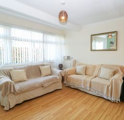 A living room with two covered sofas and a wooden cabinet with glass doors at Chalet 469 Newport Norfolk