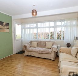 A living room with two sofas and a green accent wall at Chalet 469 in Newport Norfolk