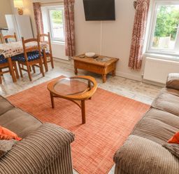 A living room with a dining table and sofa at Sea View Loft in Rosudgeon