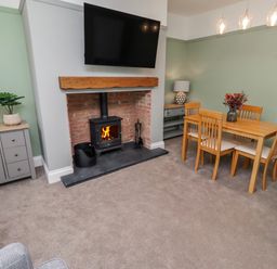 A living room with a fireplace and dining table at 3 Lisburn Street Alnwick