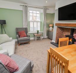 A living room with a sofa and dining table at 3 Lisburn Street Alnwick