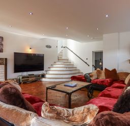 A living room with a sofa and television at Delmonte Lodge in Torquay