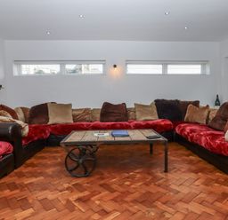 A living room with a large sectional sofa and coffee table at Delmonte Lodge in Torquay