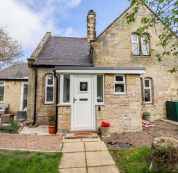 An exterior view of a house showing a door and pathway at The Lodge in Powburn