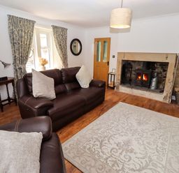 A living room with a fireplace and sofa at The Lodge Powburn