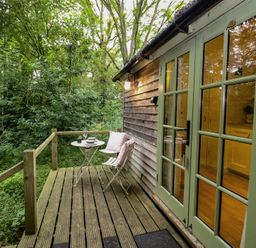 An outdoor patio with a table and chairs at Woodlands Retreat Shepherd's Hut Brundish near Laxfield
