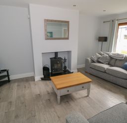 A living room with two grey sofas a wooden coffee table a fireplace and a television at C65 Cahermore Holiday Village in Enniscrone County Sligo