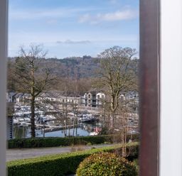 A view of a marina with boats and buildings at Marina View in Bowness-On-Windermere