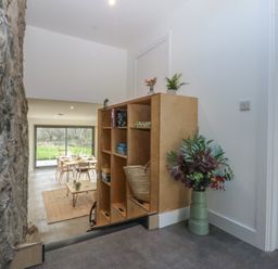 A dining room with a table and chairs at Tithe Barn Lodge Capel Mawr near Malltraeth