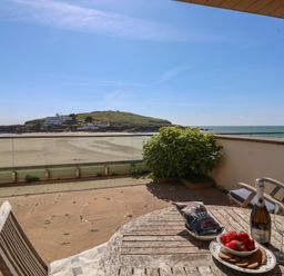 An outdoor patio with a table and chairs overlooking the sea at 6 Burgh Island in Bigbury-On-Sea