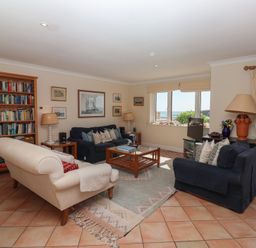 A living room with a bookshelf and sofas at 6 Burgh Island in Bigbury-On-Sea