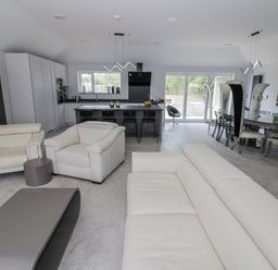 A living room with modern furniture and a kitchen area at Chillon South Littleton near Honeybourne