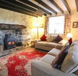 A living room with two sofas and a fireplace at Tyn Y Graig in Fairbourne