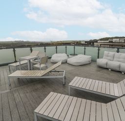 An outdoor terrace with seating and a table at The Black Barnacle in Portreath
