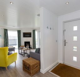 A living room with furniture and a door at Dahlia in Portreath