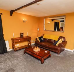 A living room with a sofa and coffee table at Petty Knowes Cottage near Rochester