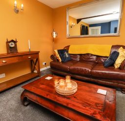 A living room with a sofa and coffee table at Petty Knowes Cottage near Rochester