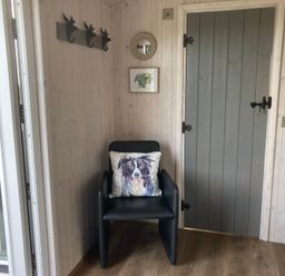 An entryway with a chair and hooks at Little Acre in Oxenhope
