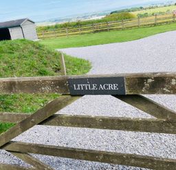 A gate labeled Little Acre leading to a gravel path at Little Acre in Oxenhope