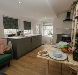 A kitchen with dining table and fruit at Sea Pink Studio in Swanage