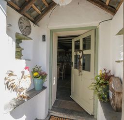An entrance with a door and plants at High Ickenthwaite Farmhouse in Ulverston