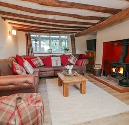 A living room with a sofa and fireplace at High Ickenthwaite Farmhouse in Ulverston