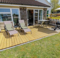 An outdoor area with lounge chairs and a table at Plimoth N8 Yarmouth