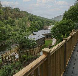 A view of cabins and a river surrounded by trees at Hodge Luxury Pod Keswick