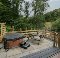 An outdoor space with a hot tub and a picnic table at Dubs Luxury Family Pod in Keswick
