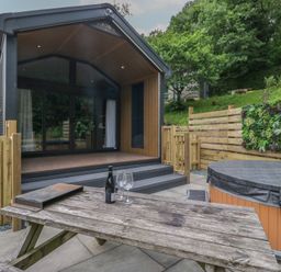 An outdoor area with a pod and hot tub at Dubs Luxury Family Pod in Keswick
