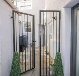 An outdoor area with a gate and planters at Hocking Cottage St Marychurch