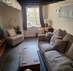 A living room with a sofa and coffee table at Hocking Cottage in St Marychurch