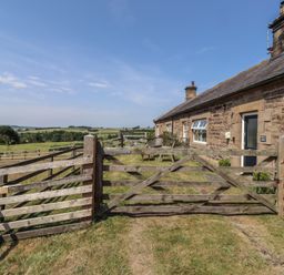 A wooden gate leading to a house in a field at Folly View in Eglingham