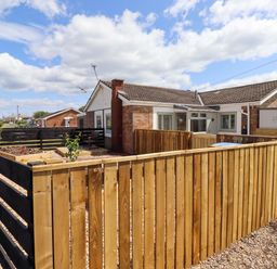 A house with a garden surrounded by a wooden fence at North Sands in Beadnell