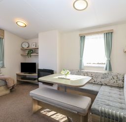 A living room with seating area dining table and television at 31B Foxburrow Hang in Fritton near Belton Norfolk