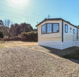 A mobile home on a gravel lot with trees and bushes in the background at 31B Foxburrow Hang in Fritton near Belton Norfolk