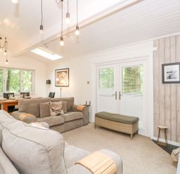 A living room with sofas a dining table and a wood burning stove at Serenity in Skiptory Howe 10 White Cross Bay near Windermere
