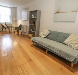 A living room with a sofa and armchairs at Harbourside in Weymouth