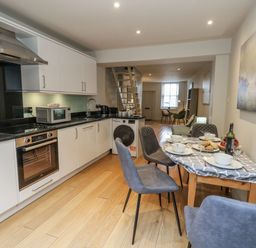 A kitchen with appliances and a dining table at Harbourside in Weymouth