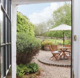 A view of a garden with a table and chairs at 2 New Mill Cottages in North Bovey