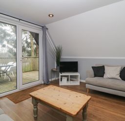 A living room with sofa coffee table and TV at Valley Lodge 38 in St Ann's Chapel Cornwall