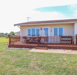 An outdoor space with a wooden deck and windows at Boa Vista in Bacton