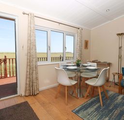 A dining room with a table and chairs at Boa Vista in Bacton