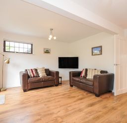 A living room with two sofas and a television at Kernyk in Camelford