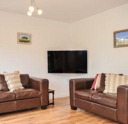 A living room with sofas and a television at Kernyk in Camelford