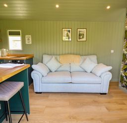 A living room with a sofa and bar counter at Bluebell in Grimsby
