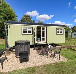 A tiny house with a hot tub and seating area at Magnolia in Grimsby