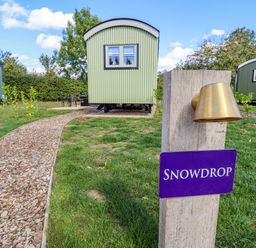 An outdoor area with shepherd's huts and a pathway at Snowdrop in Grimsby