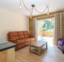 A living room with a sofa and coffee table at Barn Owl Lodge