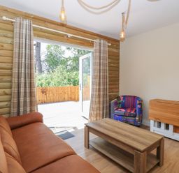 A living room with a sofa and coffee table at Barn Owl Lodge